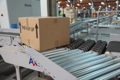 Roller conveyor merges parcel onto conveyor line