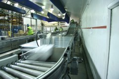 Belt conveyor on incline and roller conveyor transports parcels at high speeds